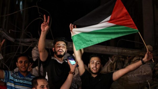 People wave the Palestinian flag as they celebrate in the street following a ceasefire brokered by Egypt between Israel and the two main Palestinian armed groups in Gaza on 21 May, 2021