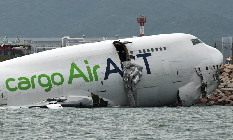 Cargo Plane Crash at Hong Kong Airport Leaves Two Dead Boeing 747 freighter lost control upon landing, broke through perimeter fencing, and collided with an airport patrol vehicle, forcing it into the water.
